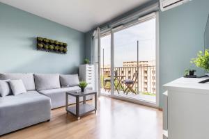 a living room with a couch and a large window at Krowodrza Apartment's in Krakow