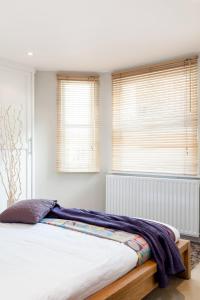 ロンドンにあるMadison Hill - Fernlea Garden 2 - One bedroom homeのベッドルーム1室(ベッド1台、窓2つ付)