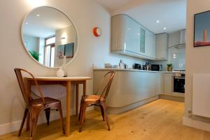 ロンドンにあるMadison Hill - Byrne Garden 2 - One bedroom homeのキッチン(テーブル、椅子、鏡付)