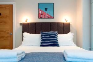 a bedroom with a large bed with a wooden headboard at Madison Hill - Byrne Garden 2 - One bedroom home in London