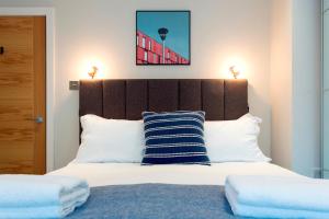 ロンドンにあるMadison Hill - Byrne Garden 2 - One bedroom homeのベッドルーム1室(大型ベッド1台、木製ヘッドボード付)