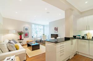 White Hill House 1 في لندن: مطبخ وغرفة معيشة مع أريكة وطاولة