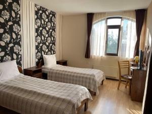 a hotel room with two beds and a window at Cassiopea Villas in Pamporovo