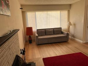 ein Wohnzimmer mit einem Sofa und einem roten Teppich in der Unterkunft Cozy Artistic Room Available in Delta Surrey Best Price in Delta