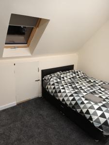 - une chambre avec un lit à damiers noir et blanc dans l'établissement 188 marsh road, à Luton