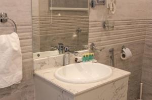 y baño con lavabo blanco y espejo. en الماطر للشقق الفندقية Almater Hotel Suites, en Al Khafji