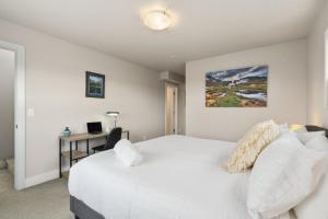 - une chambre avec un lit blanc et un bureau dans l'établissement Elegant Oasis - Fireplaces, King Beds, Mtn Views!, à Fort Collins