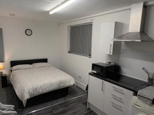 Dormitorio pequeño con cama y microondas en 188 marsh road en Luton