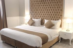 a bedroom with a large bed with a large padded headboard at الماطر للشقق الفندقية Almater Hotel Suites in Khafji