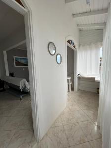 a white hallway with two mirrors on the wall at Casa c/ bela vista para Baía Sul in Florianópolis