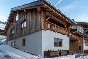 uma casa com uma fachada de madeira na neve em Chalet Abeille in Les Gets Sleeps 12 em Les Gets