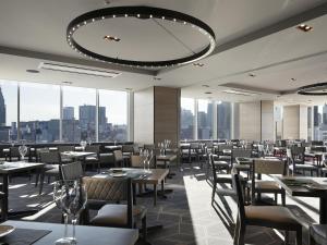 a restaurant with tables and chairs and a large chandelier at Shinjuku Granbell Hotel in Tokyo