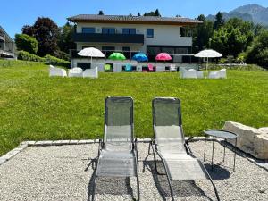eine Gruppe von Stühlen, Tischen und Sonnenschirmen in der Unterkunft Boardinghouse in Bad Reichenhall