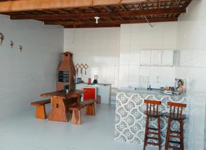 a kitchen with wooden stools and a table in a room at Casa Sunset Beach Abaís in Estância