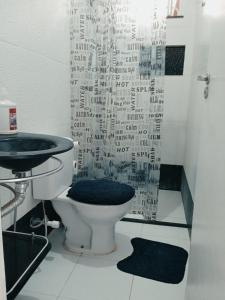 a bathroom with a toilet and a shower curtain at Casa Sunset Beach Abaís in Estância