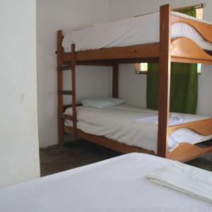 2 Etagenbetten in einem Zimmer mit einem Bett in der Unterkunft ANGELES DEL MAR in Máncora