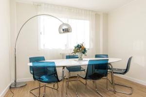 mesa de comedor con sillas azules y lámpara en Casa Elisa con piscina y parking, en Zaragoza