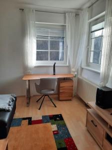 einen Schreibtisch und einen Stuhl in einem Zimmer mit Fenster in der Unterkunft Wohnen in Graz Mariatrost in Graz