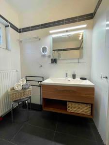 Wohnen in Graz Mariatrost في غراتس: حمام مع حوض ومرآة