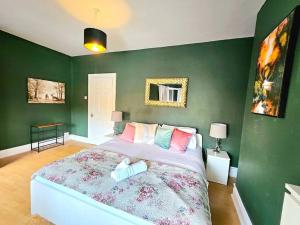 1 dormitorio con 1 cama grande y paredes verdes en Splendid Stay By Sensational Stay Short Lets & Serviced Accommodation At Manor Street, en Belfast