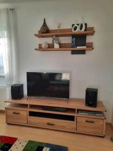 a entertainment center with a flat screen tv and speakers at Wohnen in Graz Mariatrost in Graz