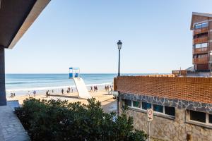 vistas a una playa con gente y al océano en Apartamentos Dada, en Zarautz