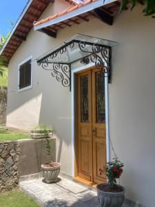 an entrance to a house with a wooden door at Casas No Centro Histórico (vila) in Ilhabela