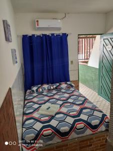 1 dormitorio con 1 cama con cortina azul en Pousada Galinhos en Galinhos
