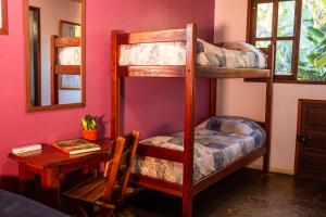 a room with two bunk beds and a table at Pousada Tatu Feliz in Vale do Capao