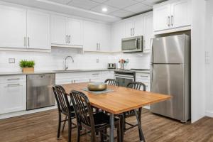 een keuken met een houten tafel en een roestvrijstalen koelkast bij Mountain Modern Hideaway in Canmore