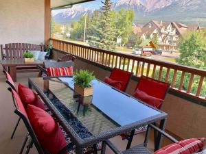 een tafel en stoelen op een balkon met uitzicht bij Mountain Modern Hideaway in Canmore