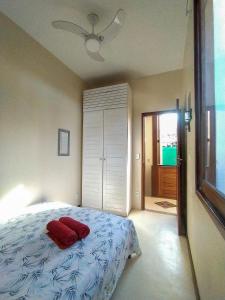 a bedroom with a bed with a red pillow on it at Casa Aberta in Itacaré