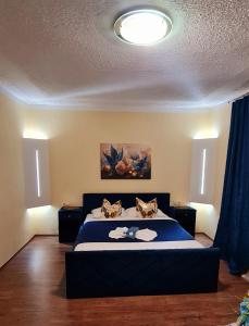 a bedroom with a bed with a blue bedspread at Genex-M in Bugojno