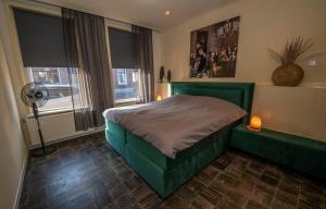 een slaapkamer met een groen bed en een raam bij Appartement 1 in Diever