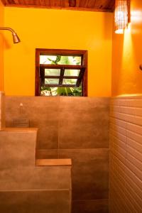 La salle de bains est pourvue d'un lavabo et d'une fenêtre. dans l'établissement Pousada Tatu Feliz, à Vale do Capão