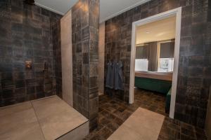 a bathroom with a walk in shower next to a bed at Appartement 1 in Diever