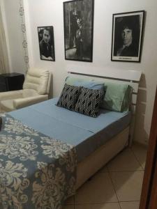 a bed in a room with pictures on the wall at Av Atlântica - Beira Mar de Copacabana - posto4 in Rio de Janeiro