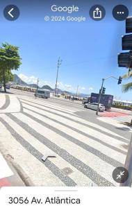 a street with a crosswalk with cars on the road at Av Atlântica - Beira Mar de Copacabana - posto4 in Rio de Janeiro