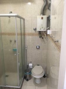 a bathroom with a toilet and a glass shower at Av Atlântica - Beira Mar de Copacabana - posto4 in Rio de Janeiro