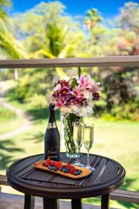 a table with a bottle of wine and glasses at Grand Champions Golf Villas 94 in Wailea