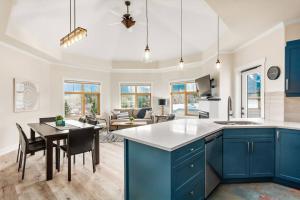 a kitchen and living room with blue cabinets and a table at The Grand Escape Downtown Canmore in Canmore