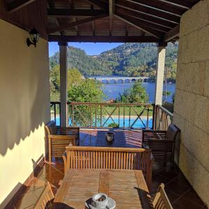 een patio met een tafel en stoelen en uitzicht op het water bij Casa de Pichoses in Geres