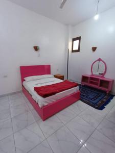 1 dormitorio con cama roja y espejo en Egypt lovers home, en Luxor