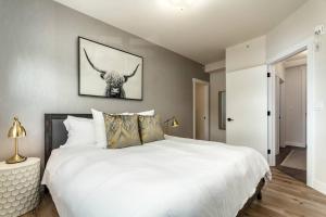 a bedroom with a large white bed with a bull on the wall at The Grand Escape Downtown Canmore in Canmore