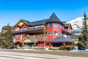 a large red building with a black roof at The Grand Escape Downtown Canmore in Canmore