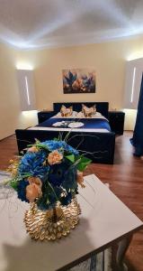 a bedroom with a bed and a table with flowers on it at Genex-M in Bugojno