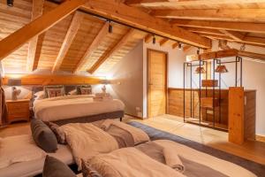 una camera con due letti in una stanza con soffitti in legno di Chalet Abeille in Les Gets Sleeps 12 a Les Gets