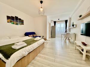 a bedroom with a large bed and a desk at Studio 1 MEGA MALL National Arena in Bucharest