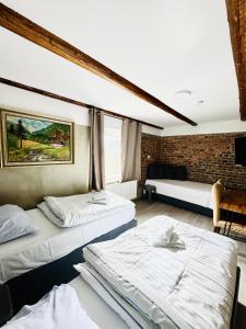 2 camas en una habitación con una pared de ladrillo en PHOENIX Apartments - Monteurwohnung mit RIESIGER Parkfläche en Bielefeld