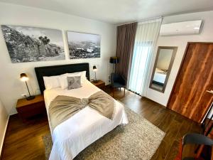 1 dormitorio con 1 cama grande con sábanas blancas en HOTEL MINA REAL en Cedral